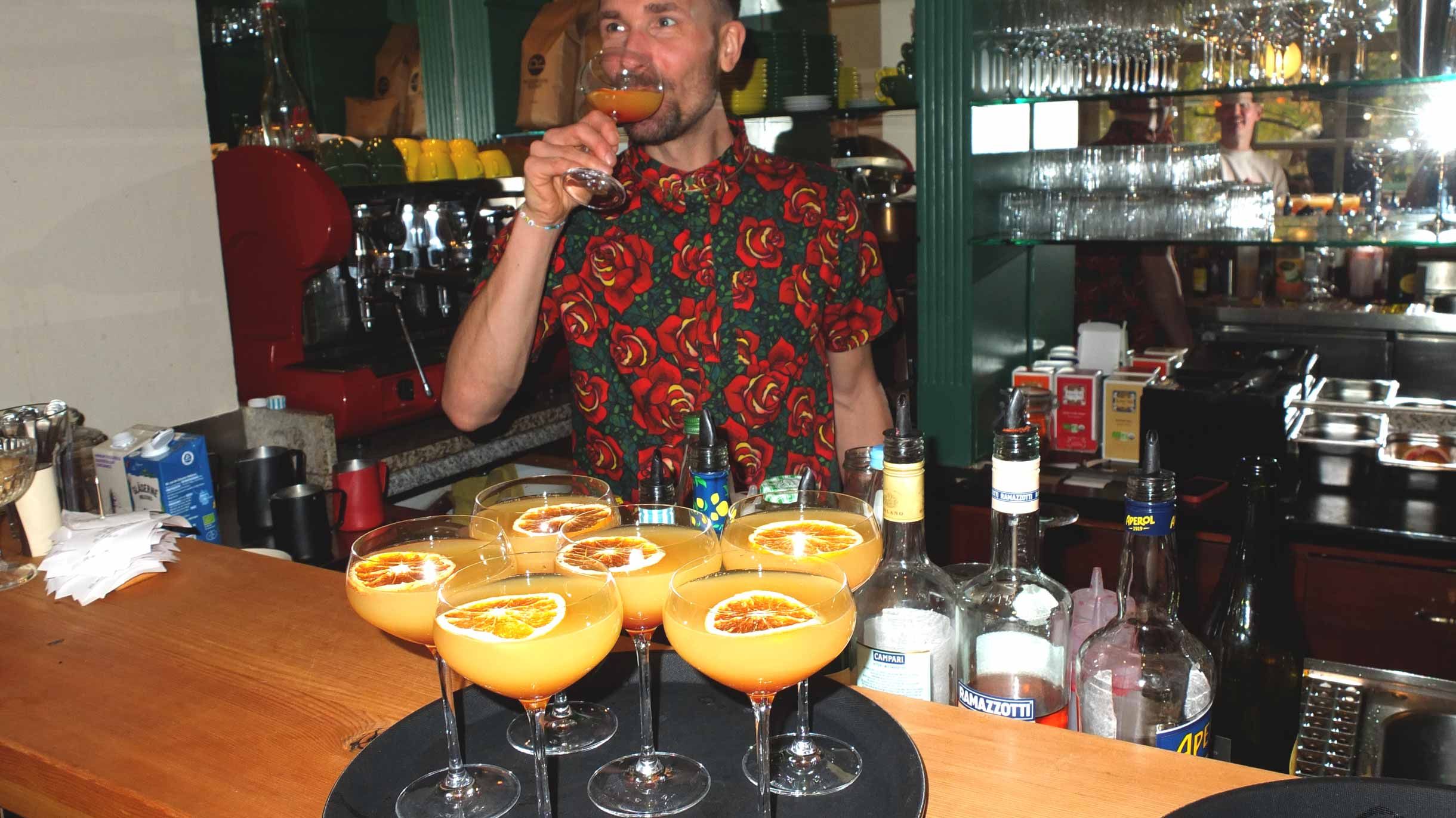 Max mixt Mimosas und probiert sie hinter der Bar